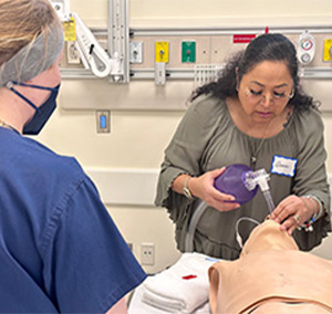 A medic practices her skills on a mannequin 