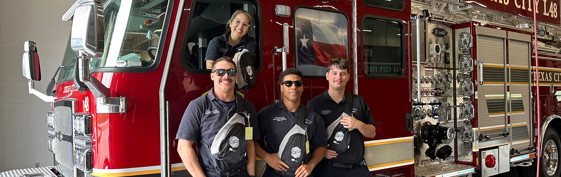 group of first responders in and in front of fire truck