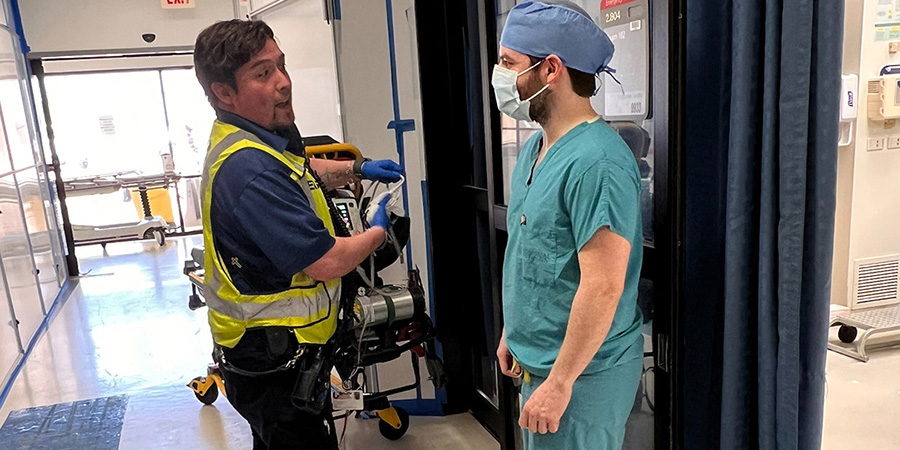 Medic talks to doctor in ER hallway