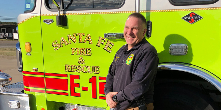 Medic stands by fire truck door