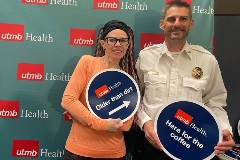 UTMB EMS members posing for photo  placards