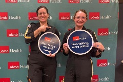 UTMB EMS members posing for photo  placards