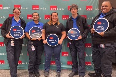 UTMB EMS members posing for photo  placards