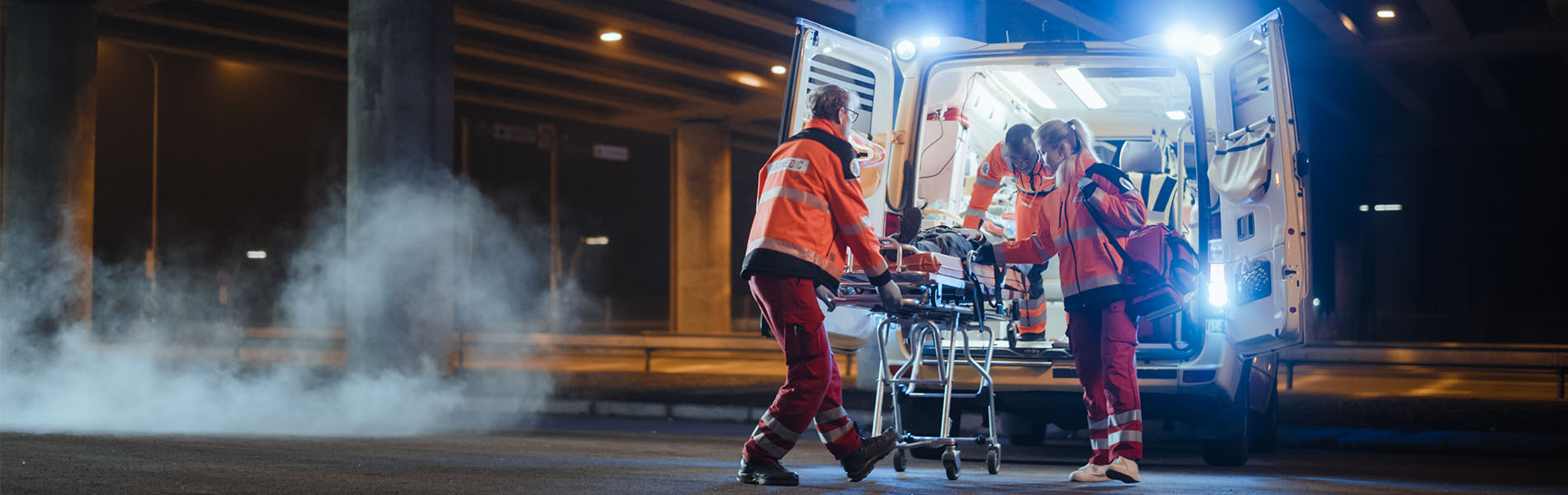 EMS crew wheeling patient into ambulance