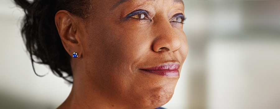 A woman looks thoughtfully into the distance, reflecting on age-related changes in her vision.