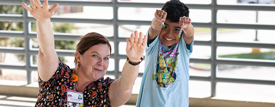 UTMB clinician and child patient showing and celebrating the gene therapy being provided