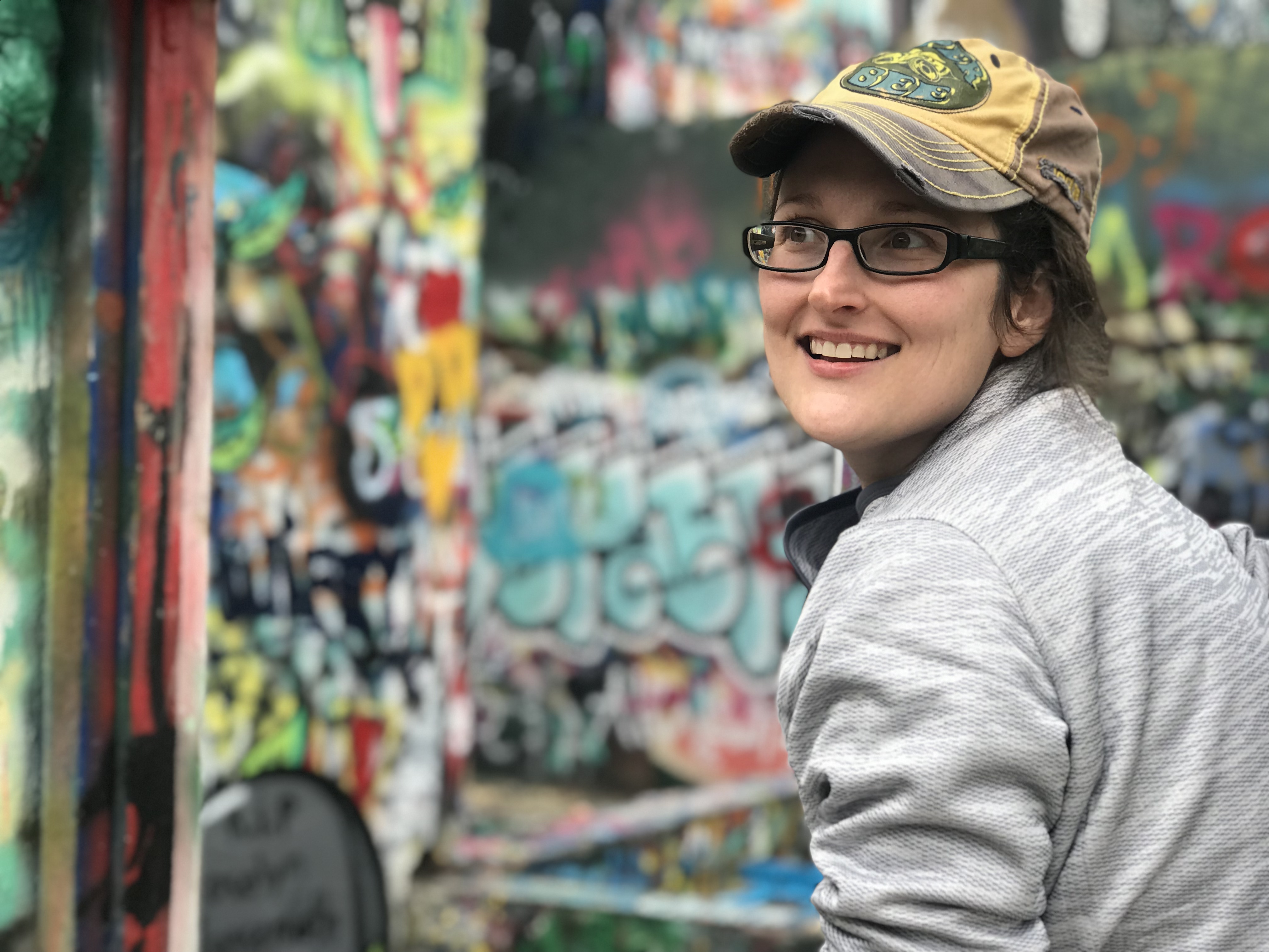 Image of Tammi Moran in front of colorful mural