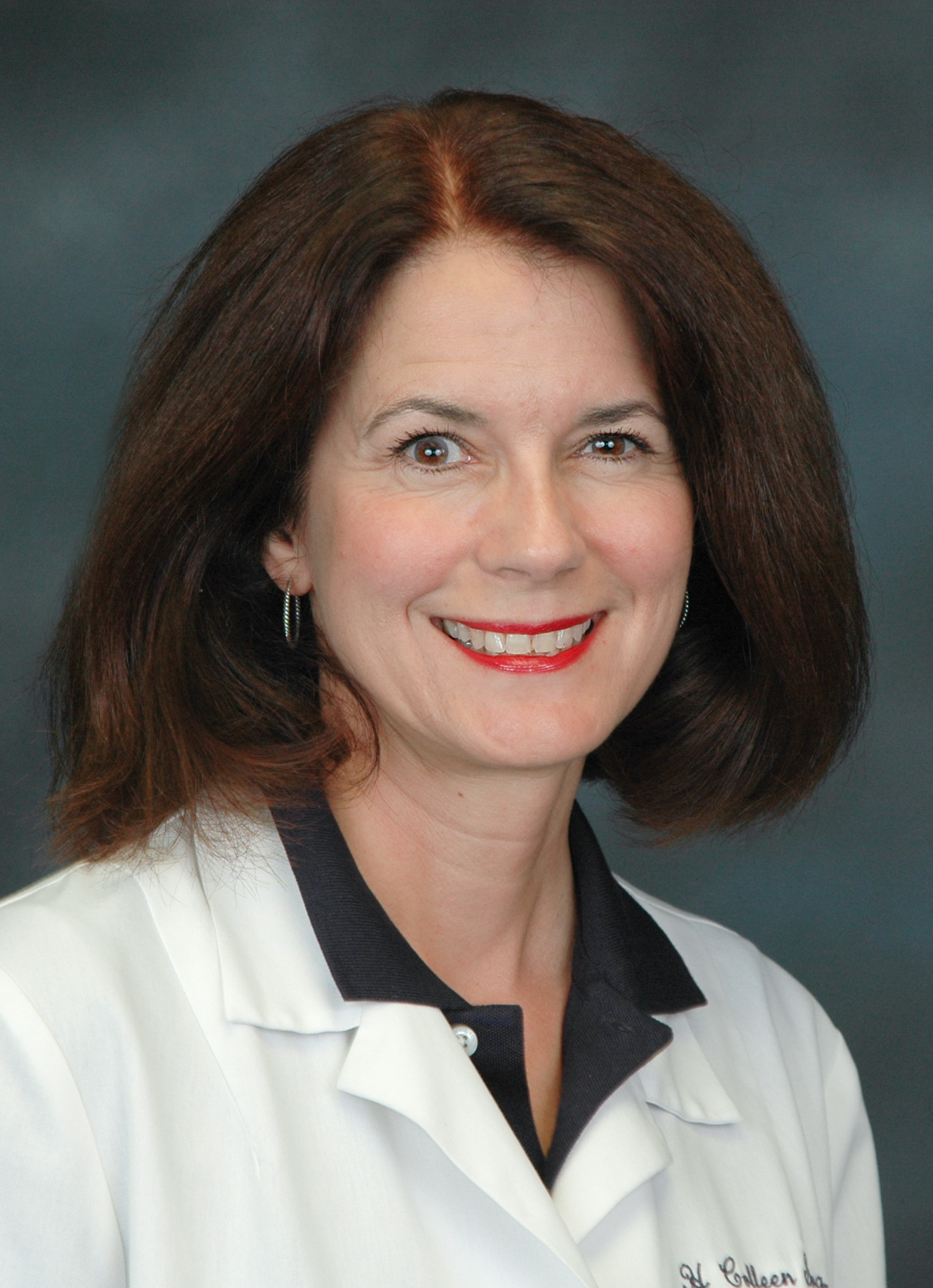 headshot image of surgical oncologist Dr. Colleen Silva. She is a brunette with chin-length hair and is wearing her white coat and smiling