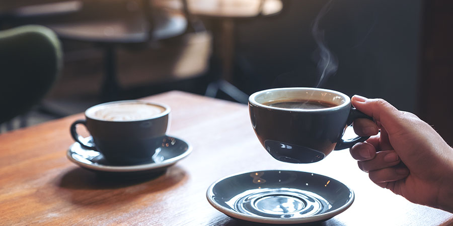 A hand holding a cup of coffee