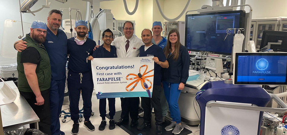 Eight people in a treatment grouped around a congratulations banner marking the first case with the Farapulse pulse field ablation system