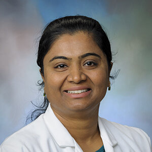 Headshot image of nurse Sinju Jacobs wearing white coat