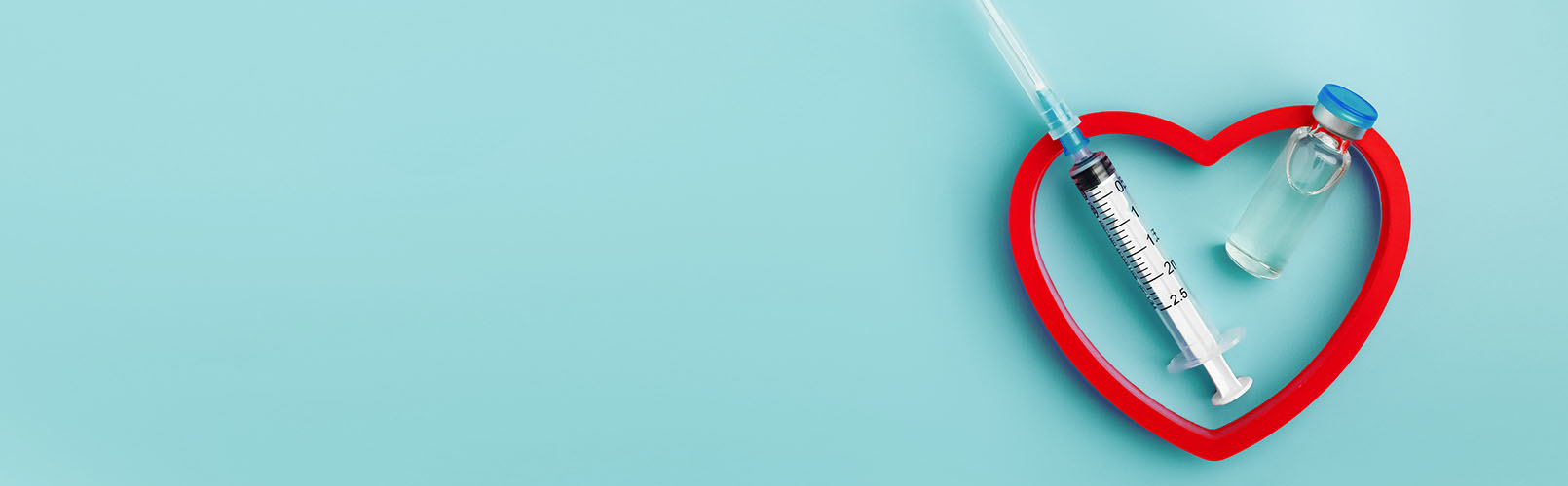 teal background with a red heart, syringe and medicine vial