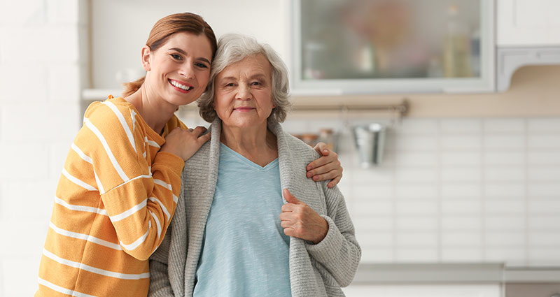 Elderly woman with female caregiver in kitchen