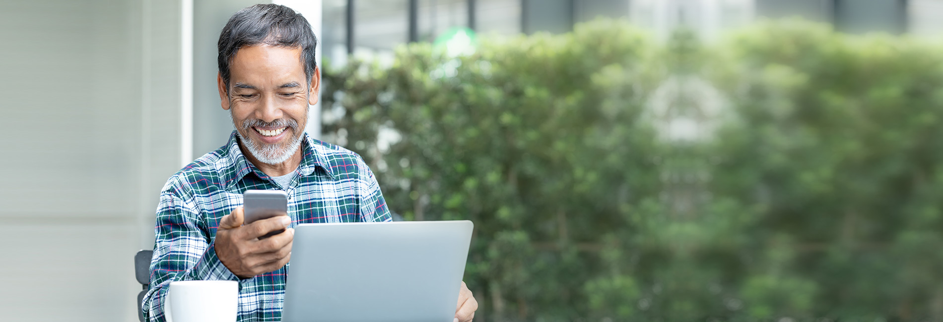 Man on computer and looking at phone