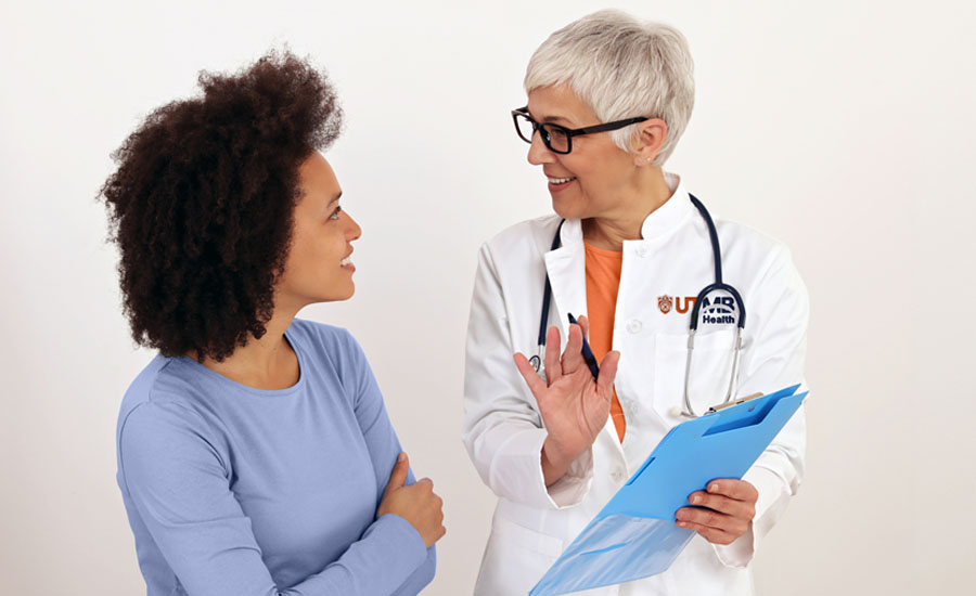 Médica de UTMB Health y una paciente charlando alegremente