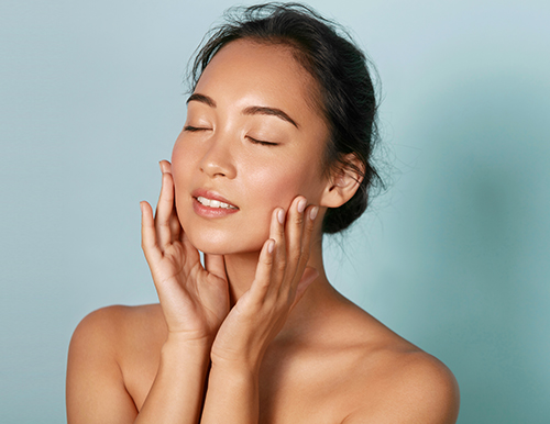 Woman with closed eyes cupping her cheeks