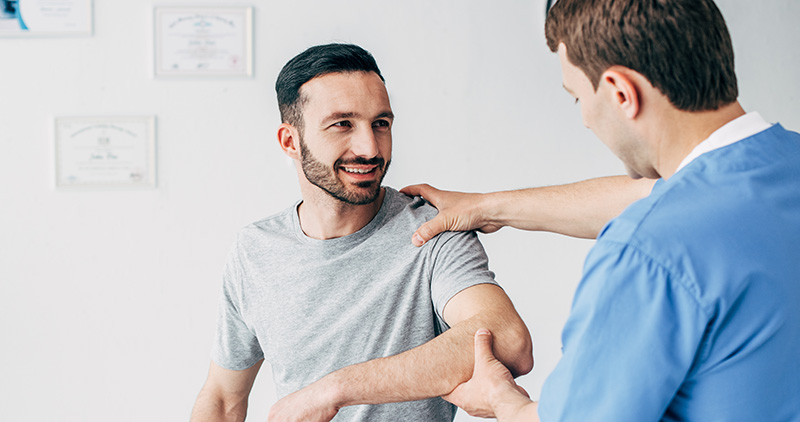 Man getting arm examined by doctor