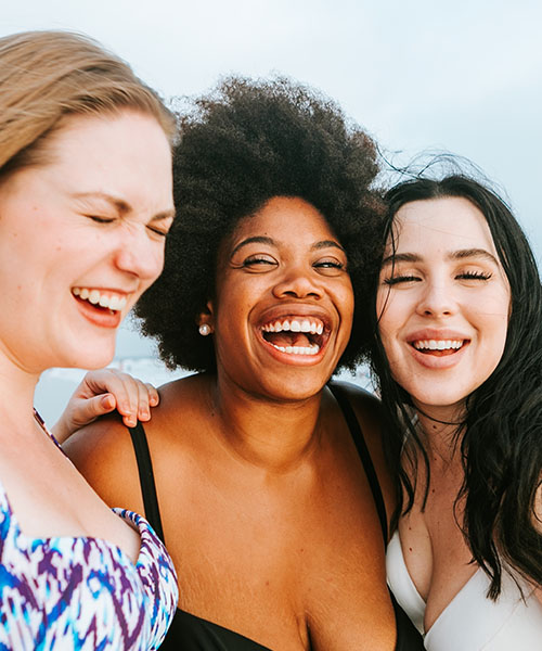 Three women smiling and laughing