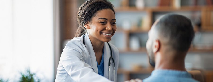 A UTMB healthcare provider smiles and comforts a burn care patient during a consultation.