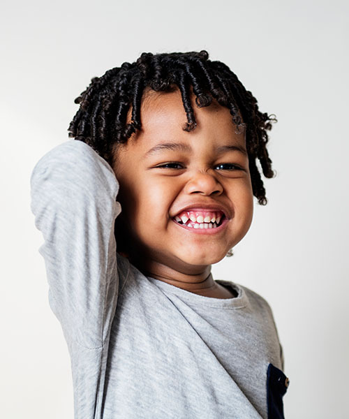 A young boy smiling big
