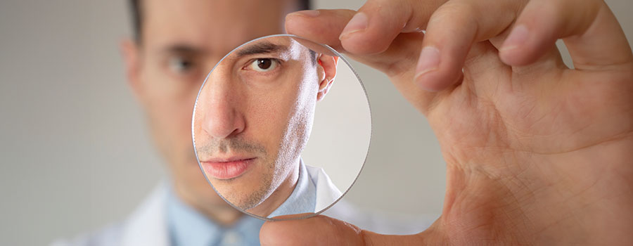 An eye care specialist holds a diagnostic lens, used to examine the eye during medical or surgical evaluation. 