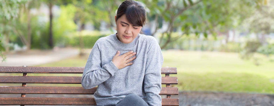 Woman with acid reflux disease pressing her fingers against sternum