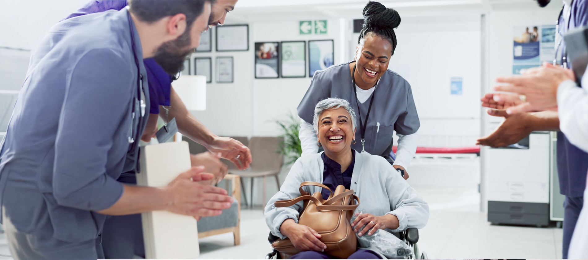 A care team celebrates with a smiling patient receiving support during cancer genetics care and treatment at UTMB Health.