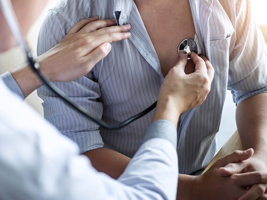heart care doctor listening to man's heart for abnormal heart rhythms
