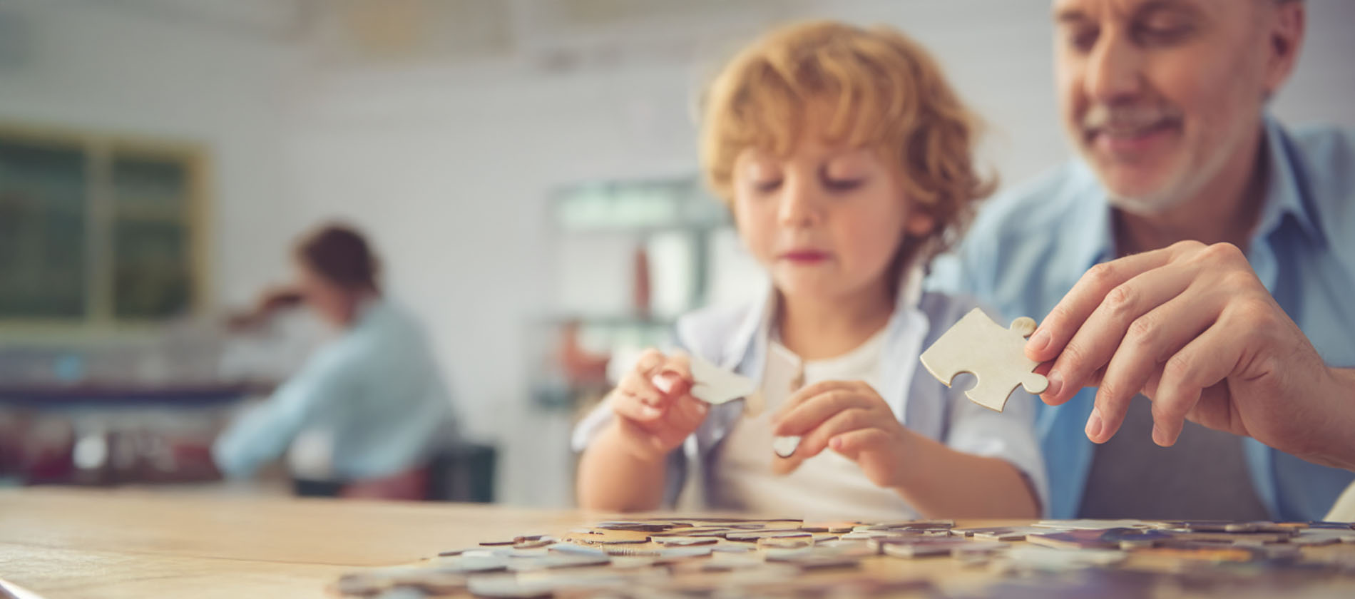 An older adult and a child are working on a puzzle together at a table, symbolizing brain health, focus, and cognitive function.