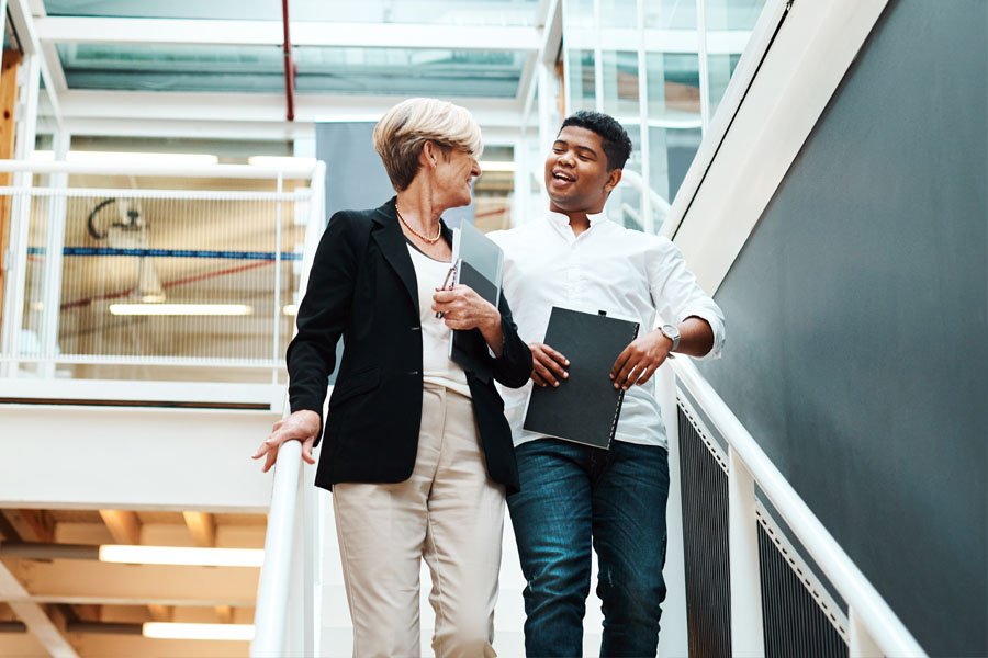 Two adults walk down the stairs together highlighting balance mobility and functional movement in nerve and muscle care.