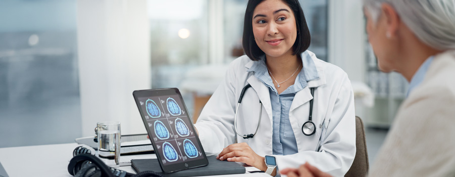 A neurologist reviews brain imaging with a patient during an immunotherapy consultation for neuroimmunologic disorders.