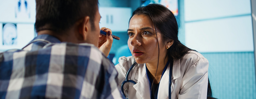 A neurologist listens closely while examining a patient during a focused medical consultation.