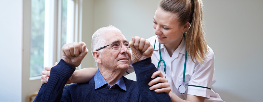 A clinician assists an older adult during an arm strength assessment for nerve and muscle disorder evaluation.