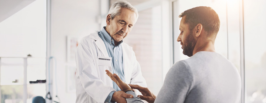 A clinician gently examines a patients hands during a peripheral nerve evaluation in a neurology clinic.