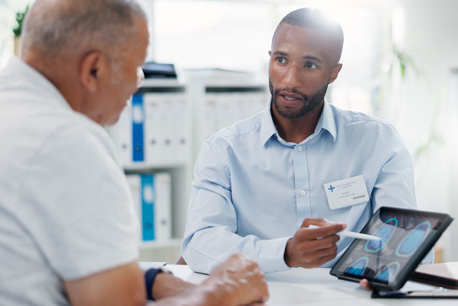 A provider reviews brain imaging with a patient while discussing next steps in neuro oncology care at UTMB Health.