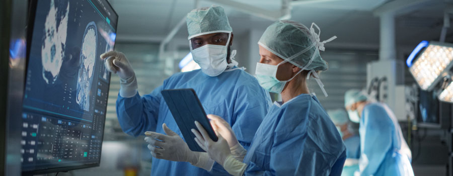 A neurosurgery team reviews brain imaging together while planning advanced neuro oncology surgery at UTMB Health.