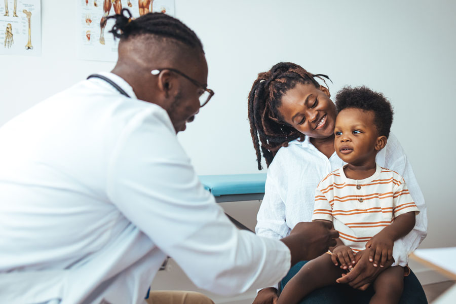 A neurosurgery provider examines a child with a caregiver present during evaluation for hydrocephalus at UTMB Health.
