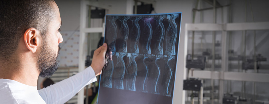 A provider reviews spine imaging to evaluate nerve related chronic pain and guide treatment planning at UTMB Health.