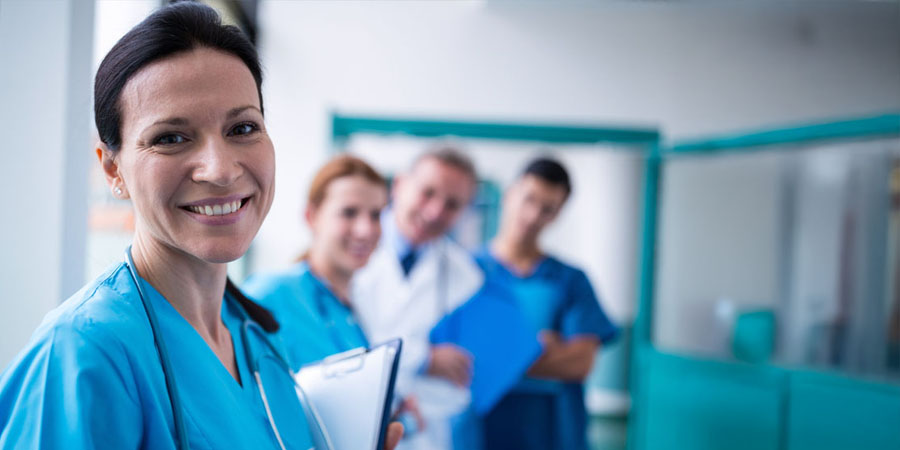 Portrait of smiling surgeon holding a clipboard in corridor