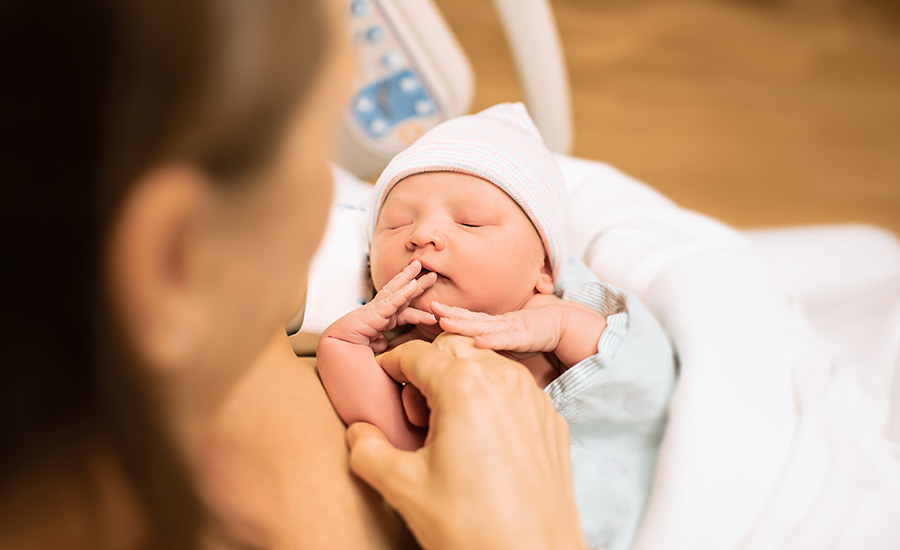 A newborn baby rests skin to skin with a parent shortly after birth at UTMB Health Labor and Delivery.