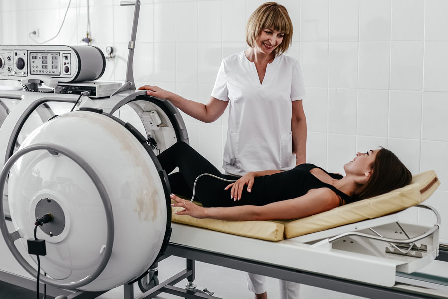 Female doctor prepping female patient in hyperbaric chamber