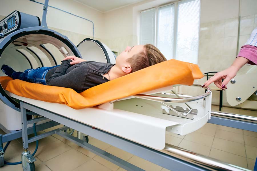 Man entering hyperbaric chamber for oxygen therapy at hospital