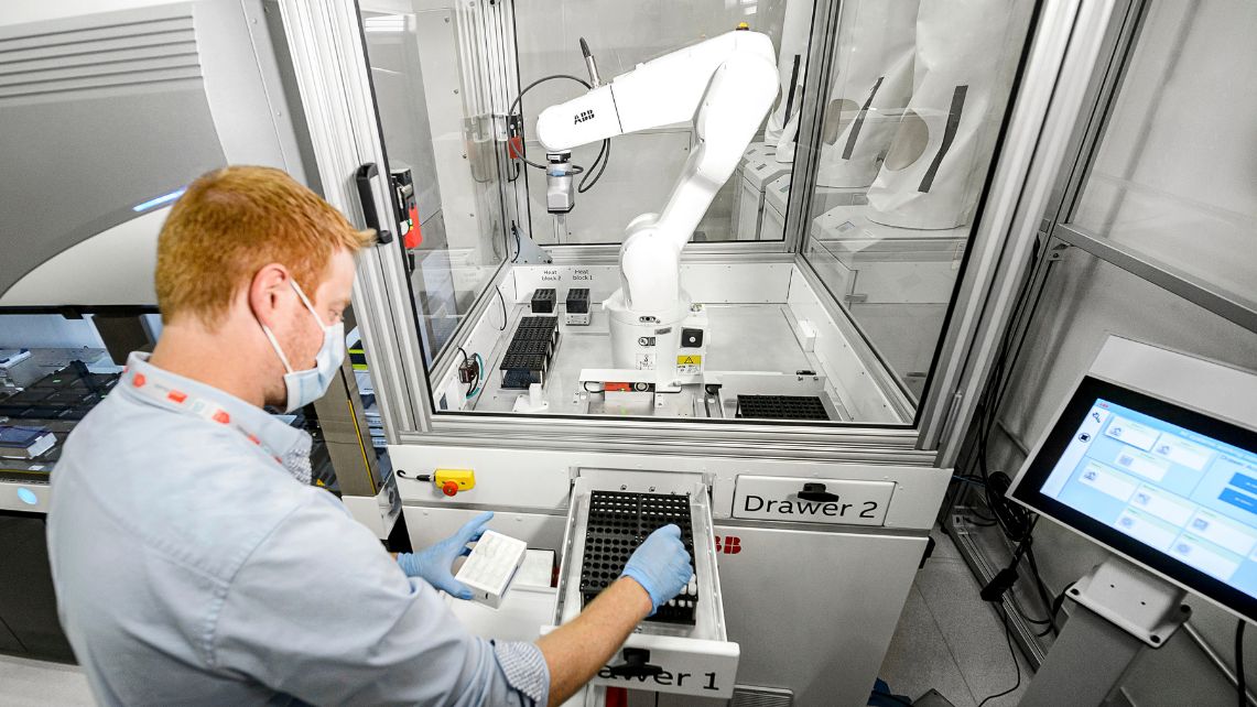 A lab worker loads blood samples into the antibody testing machine.