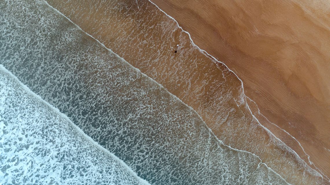 An overhead picture of waves crashing on a Galveston beach