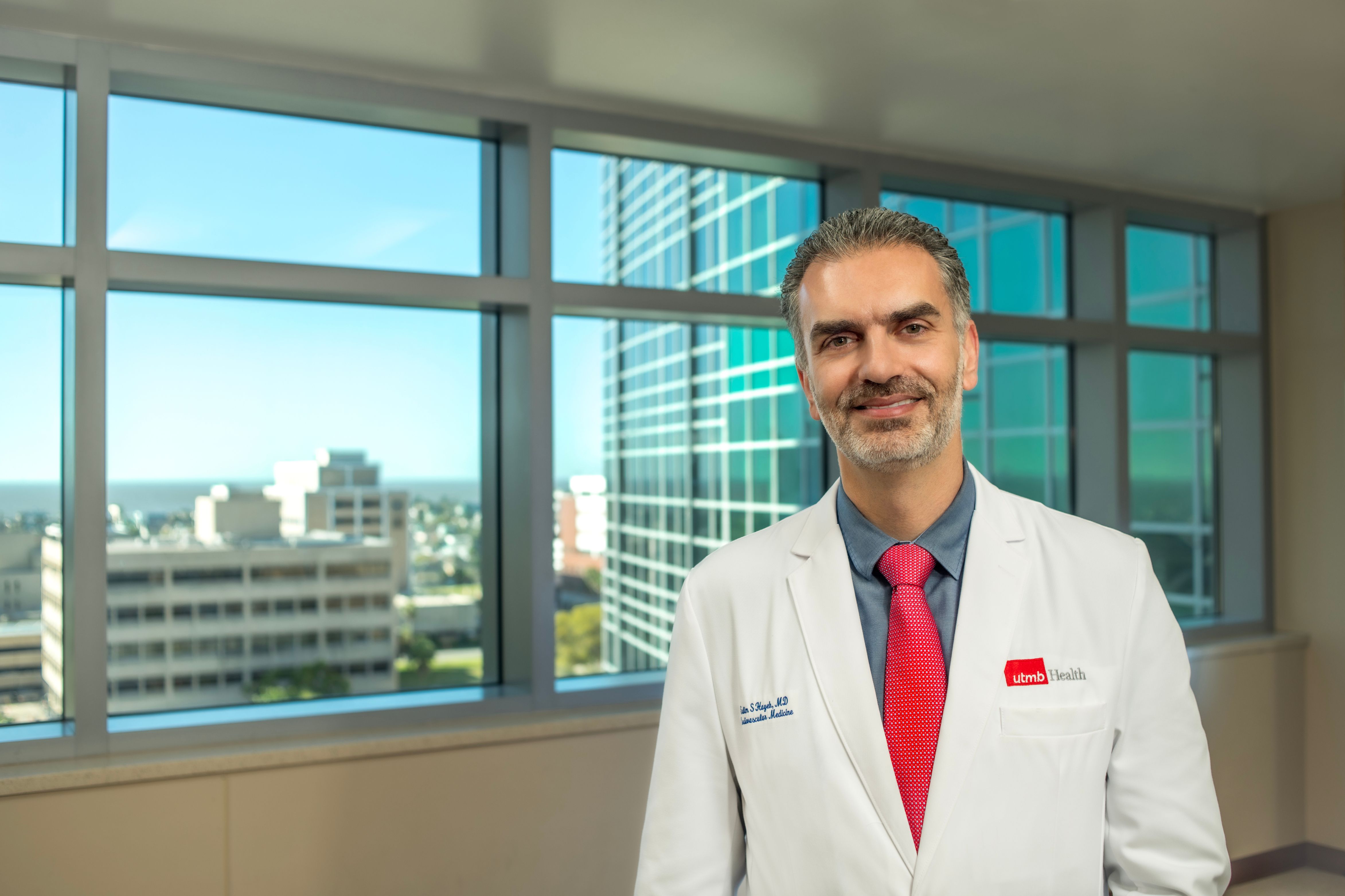 Dr. Salim Hayek stands in front of a window in Jennie Sealy Hospital