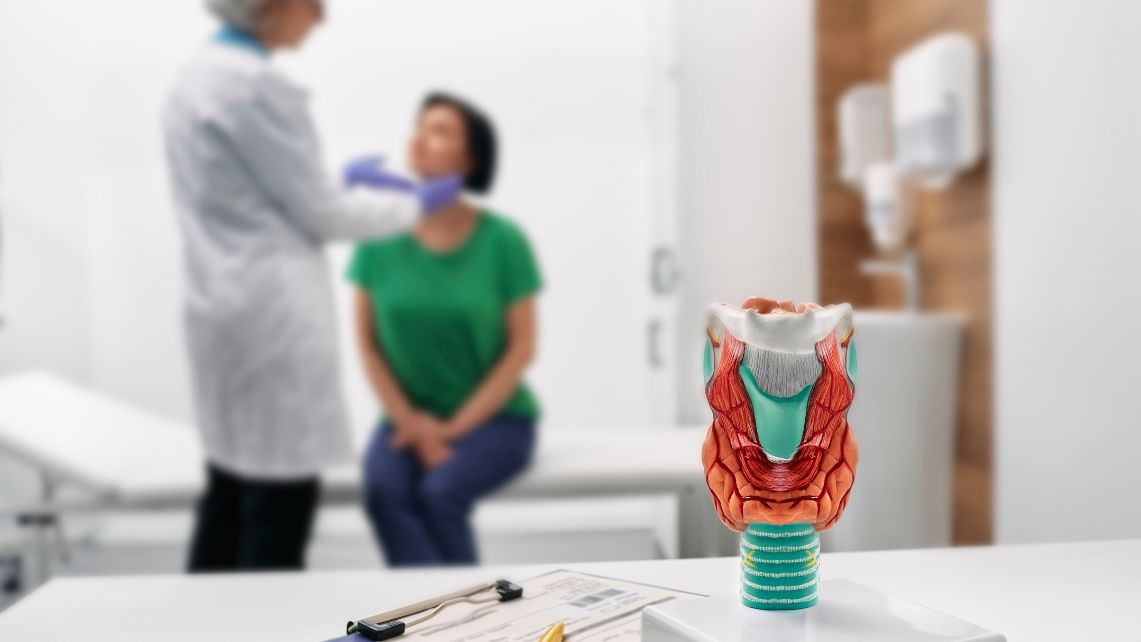 A doctor checks a patient's thyroid