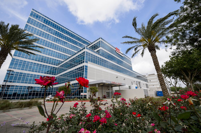 An image of the Clear Lake Campus hospital building with palm trees and rose bushes in front.