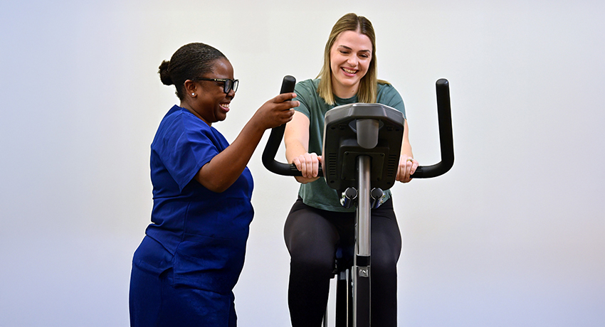 Nurse coaching patient on an exercise bike