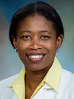 Dr. Esosa Odigie-Okon Female doctor with short brown hair wearing a white lab coat over a yellow shirt