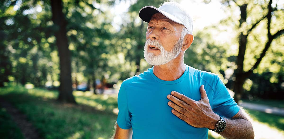 Older man holding chest